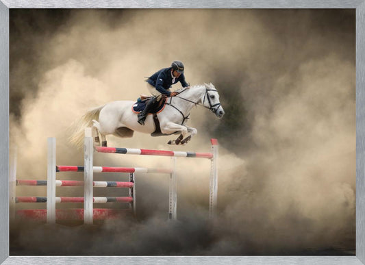 A dramatic action shot of a person in a blue jacket and helmet riding a powerful white horse as it leaps over a red and white striped obstacle, all enveloped in a swirling cloud of brown dust. Print