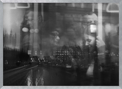 A moody black and white double exposure photograph showing a rainy London street at night with Big Ben, overlaid with the faint reflections of people inside a moving vehicle like a bus. The image has a dreamy, layered effect and is displayed in a silver frame. Print