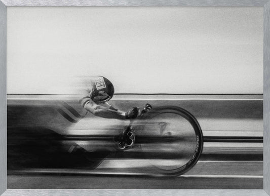 A black and white photograph captured with motion blur, showing a cyclist in an aerodynamic position racing at high speed. The background is blurred into horizontal lines, emphasizing the velocity. The image is enclosed in a silver frame. Wall Art