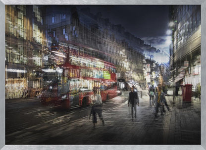 A long-exposure, artistic photograph of a busy London street at night. The motion of a red double-decker bus and pedestrians creates a blurred, ghost-like effect, capturing the vibrant energy of the city. The scene is illuminated by streetlights and building windows, all set within a silver frame. Artwork