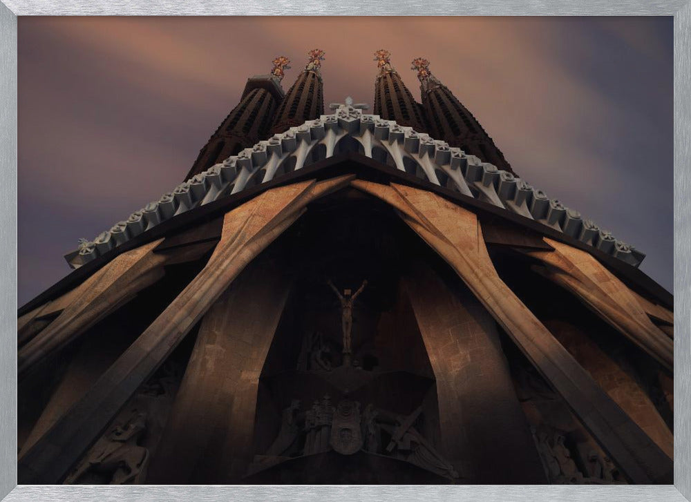A dramatic, low-angle shot of the Sagrada Familia cathedral, focusing on the intricate details of the Passion Facade against a dusky purple and orange sky. The spires tower above, while deep shadows highlight the unique, angled columns and the central sculpture of the crucifixion. Poster