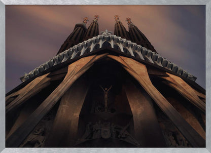 A dramatic, low-angle shot of the Sagrada Familia cathedral, focusing on the intricate details of the Passion Facade against a dusky purple and orange sky. The spires tower above, while deep shadows highlight the unique, angled columns and the central sculpture of the crucifixion. Poster