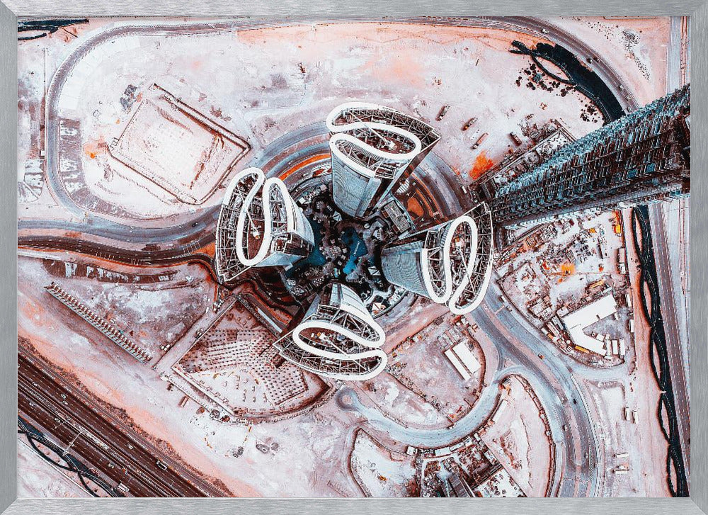 A dizzying top-down aerial photograph of five futuristic, petal-shaped skyscrapers surrounding a central turquoise pool. The surrounding urban landscape is a mix of dusty pink construction sites and curving roads, creating a surreal and abstract cityscape. Wall Art