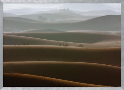 A framed photograph of a serene desert landscape, with layers of rolling sand dunes creating a sense of depth. Dark brown dunes in the foreground give way to lighter, hazy dunes and hills in the misty background. Print