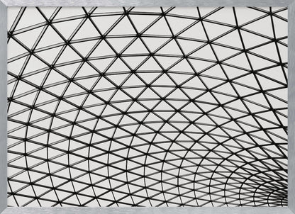 A framed, black and white photograph of a modern architectural dome ceiling. The image is a close-up, looking up at the intricate metal framework that creates a repeating pattern of triangles against the bright glass panels. Poster