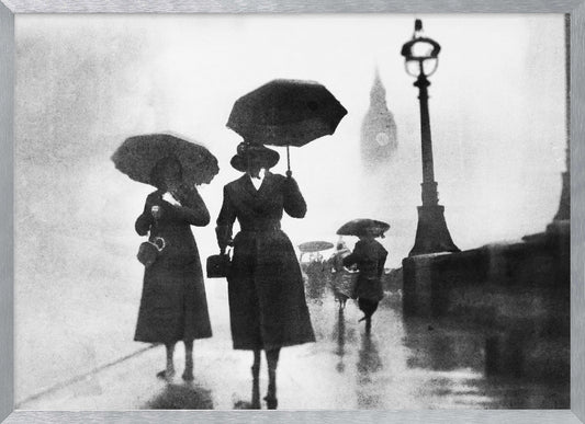 A vintage black and white photograph of people with umbrellas walking on a wet, foggy day in London. The silhouettes of the people are dark against the misty background, where the faint outline of Big Ben and a street lamp are visible. Wall Art