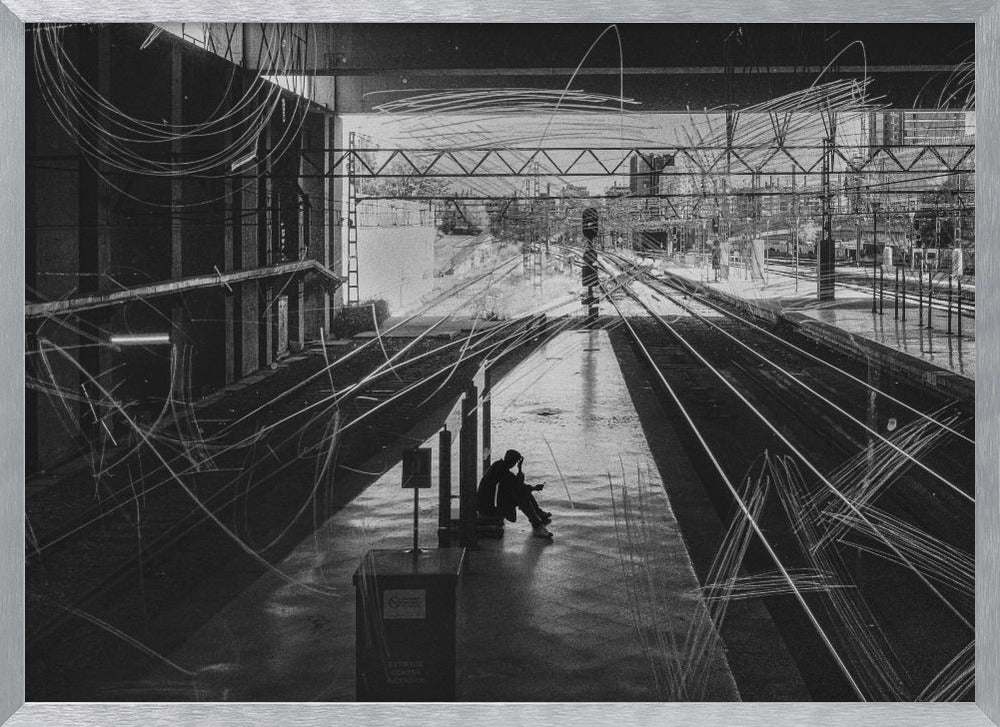 A framed, high-contrast black and white photograph of a person sitting alone on a deserted train platform, with tracks stretching into the distance. The entire scene is overlaid with frenetic white scribbles, creating an abstract and moody effect. Artwork