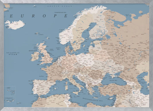 A detailed, framed map of Europe with a muted color palette. The oceans and seas are a soft blue, while the countries are various shades of beige and tan. Text labels for countries, cities, and bodies of water are clearly visible across the map. The map is housed in a simple silver-gray frame. Poster