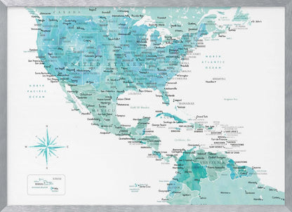 A decorative map of North, Central, and South America in a grey frame. The map has a watercolor texture in shades of blue and teal on a white background, with countries and major cities labeled in a dark font. Print