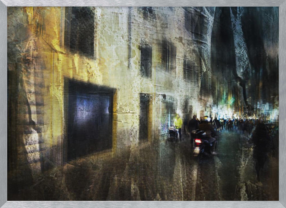 A framed abstract digital artwork depicting a busy, narrow city street at night. The image has a heavily textured, painterly style, with blurred motion effects. A weathered, yellow-lit building is on the left, while the street on the right is filled with indistinct figures of people and a motorcycle, with city lights glowing in the distance. Wall Art