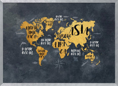 A modern world map artwork with gold leaf continents set against a textured dark gray background. Continents and oceans are labeled with decorative typography, and subtle illustrations of sea life swim in the oceans. The art is presented in a silver frame. Artwork