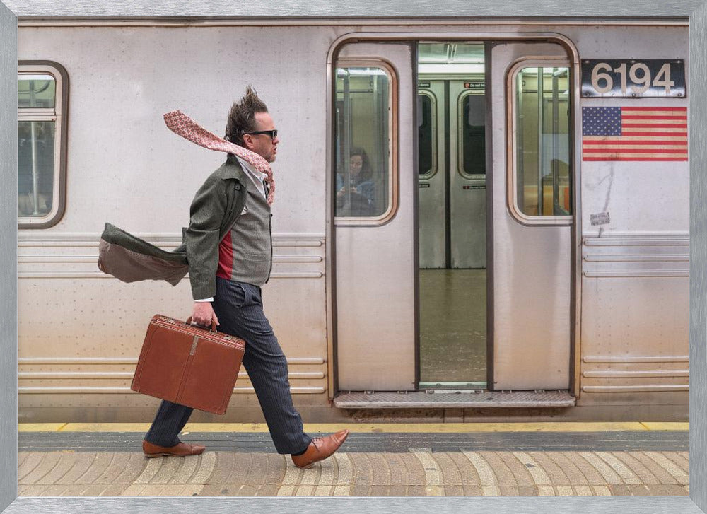 A stylish man with windblown hair and a flying scarf walks briskly along a subway platform, carrying a brown briefcase next to a silver train. Artwork