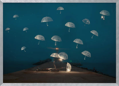 A surreal night scene with a person lying on a pier next to a glowing, transparent umbrella, while numerous other glowing umbrellas float like jellyfish in the dark blue sky above the sea, with a distant lighthouse in the background. Poster