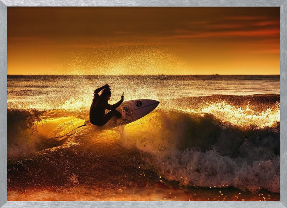A silhouetted surfer carves a turn on a sun-kissed wave during a vibrant orange sunset, with golden light reflecting off the water and sea spray. Wall Art