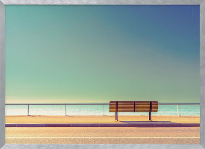 A minimalist, retro-toned photograph of a solitary wooden bench on a sunlit seaside promenade, overlooking a calm turquoise ocean under a vast, clear blue-green sky. Poster