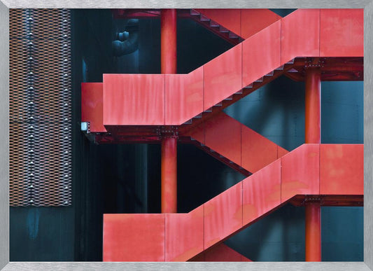 A framed abstract architectural photograph of a bright red industrial staircase zig-zagging against a dark teal wall. The composition highlights the geometric shapes and bold color contrast between the red stairs and the cool-toned background, with a silver mesh panel visible on the left side. Print