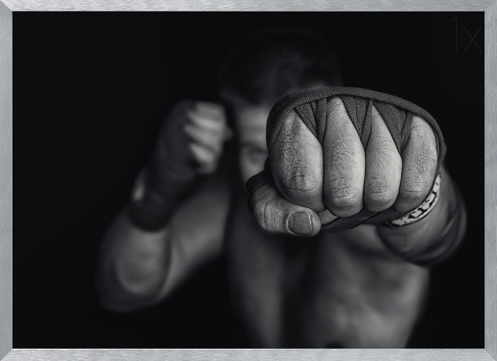 A dramatic black and white close-up photograph of a boxer's wrapped fist punching towards the camera. The fighter's body and other fist are blurred in the background, creating a powerful and intense mood. Print