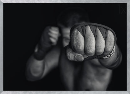 A dramatic black and white close-up photograph of a boxer's wrapped fist punching towards the camera. The fighter's body and other fist are blurred in the background, creating a powerful and intense mood. Print