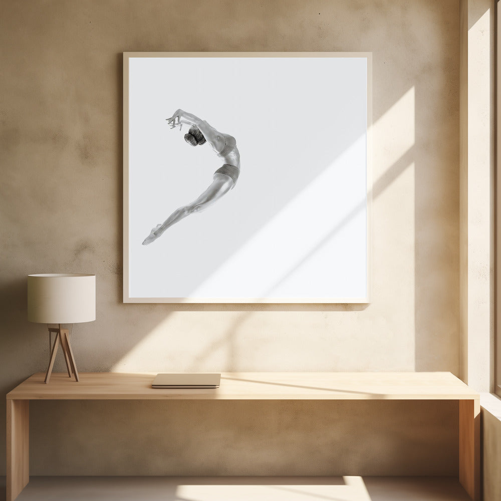 A minimalist black and white photograph of a graceful dancer frozen in mid-air, her body arched backward in an elegant C-shape against a stark white background. The artwork is presented in a light wood frame. Decor