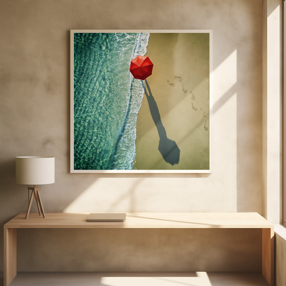 An aerial photograph of a serene beach scene, featuring a vibrant red umbrella on the golden sand next to the clear turquoise ocean. Gentle white waves lap the shore, and a long shadow from the umbrella stretches across the sand, where a trail of footprints leads away. Poster