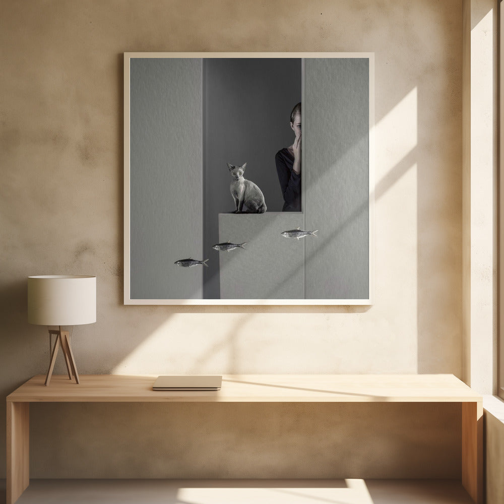 A framed, surreal monochrome photograph featuring a grey cat sitting on a ledge, with a woman partially hidden behind a wall peeking out. Three small fish appear to be floating in a line in the lower part of the image. Poster