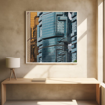 A framed close-up photograph of modern architecture, featuring a golden grid-patterned skyscraper next to a complex blue glass building with jutting levels and distorted reflections. Wall Art