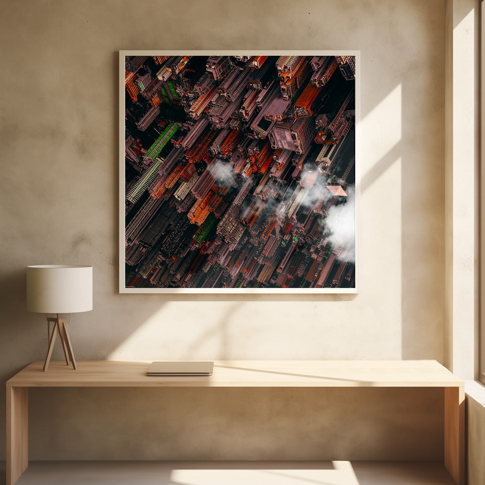 A dramatic, high-angle aerial photograph looking straight down into a super-dense, futuristic cityscape with towering skyscrapers packed together, featuring pops of orange and green among the dark buildings. Wisps of clouds float between the towers, and the image is presented in a light wood frame. Print