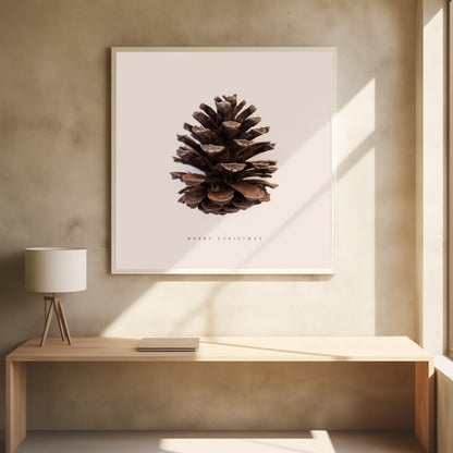 A minimalist art print featuring a single brown pinecone centered on an off-white background. The words 'MERRY CHRISTMAS' are printed in a simple, spaced-out font below the pinecone. The entire image is enclosed in a light wood frame. Artwork