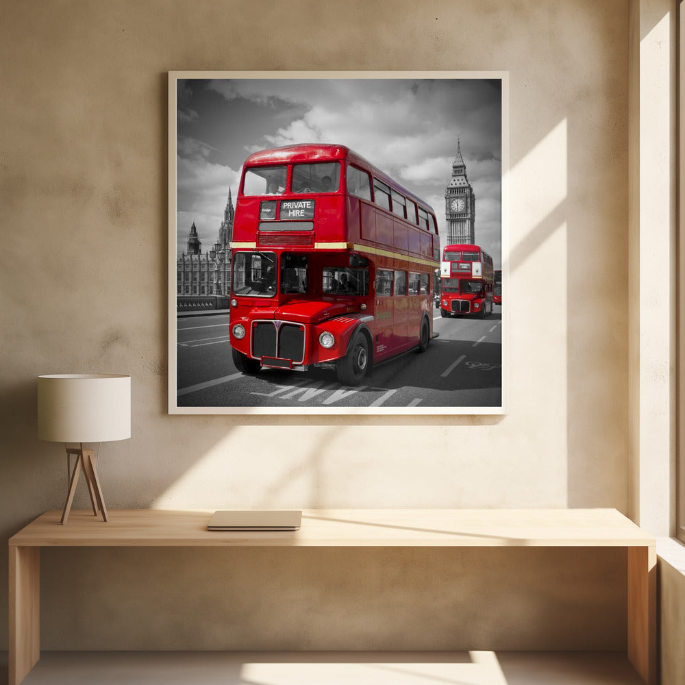 A framed, selective color photograph of a bright red, vintage double-decker bus on a bridge in London. The background, including the Big Ben clock tower, is in black and white, making the red bus stand out. Artwork