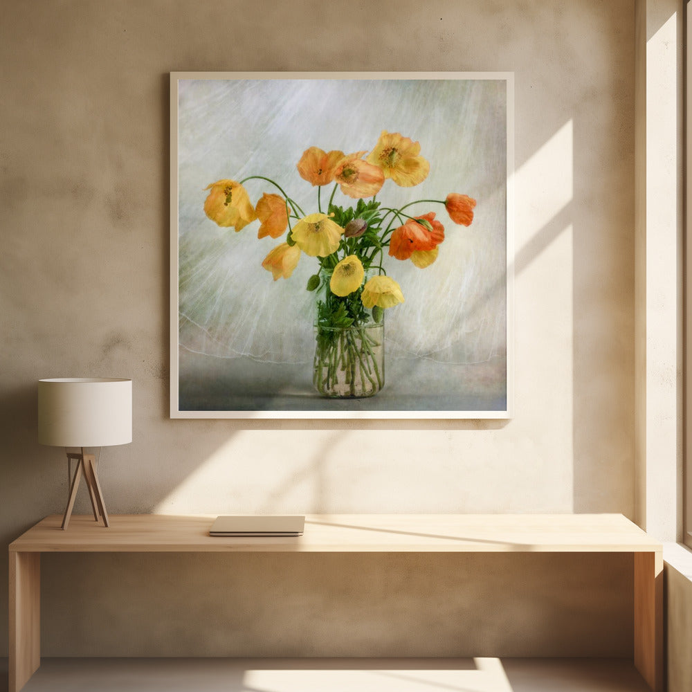 A soft-focus still life photograph of a bouquet of yellow and orange poppies in a clear glass jar, set against a delicate, light green textured background, all enclosed in a light wood frame. Print