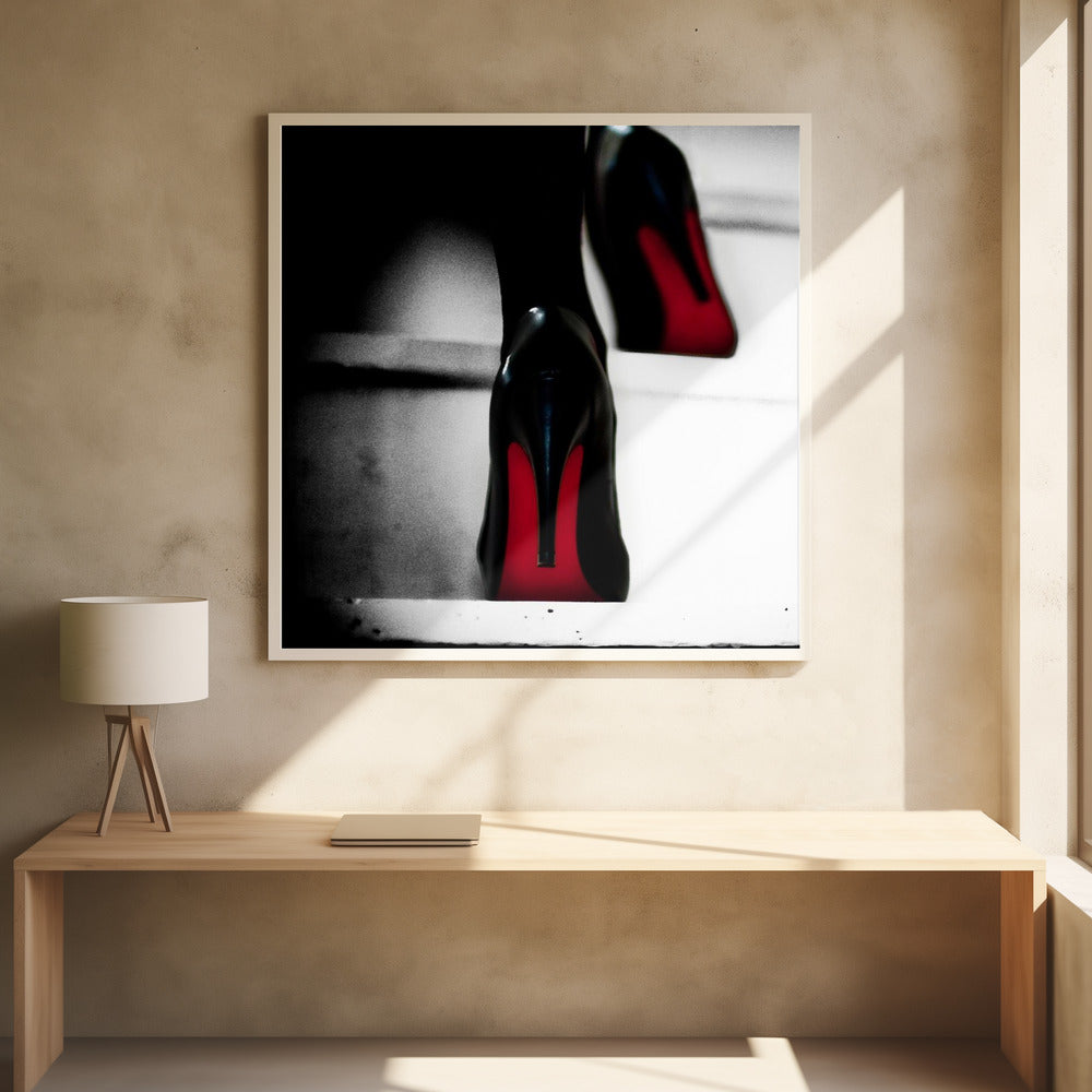 A dramatic, low-angle, black and white photograph focusing on the back of a person wearing glossy black high heels with vibrant red soles, all set within a light wood frame. Artwork
