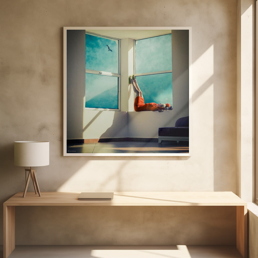 A surreal photograph of a woman in a bright orange dress lying on a wide, sunlit windowsill with her legs up against the wall. Through the large windows, a single bird is seen flying in a vibrant teal sky. The image, presented in a light wood frame, captures a moment of quiet contemplation and escape. Wall Art